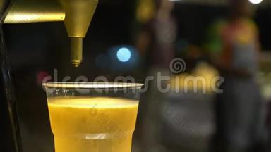 特写镜头。 男人把啤酒倒进塑料杯里。 街头美食。